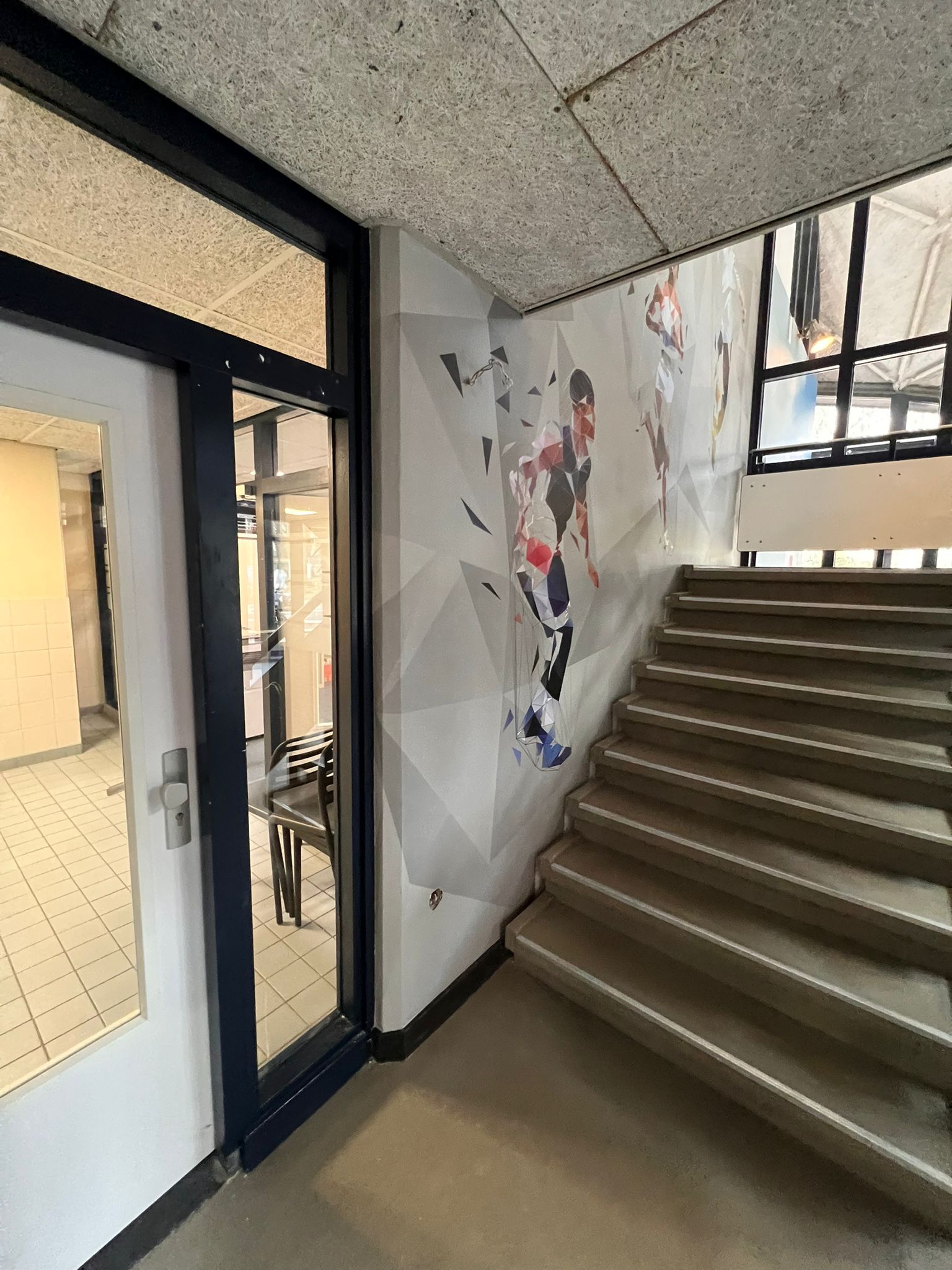 frisse uitstraling trappengat sporthal met Vinywall naadloos behang van MetroXL